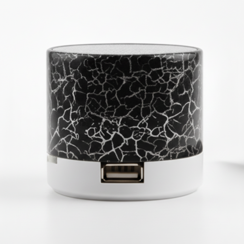 Small cylindrical device with cracked glass design next to a smartphone on a white background